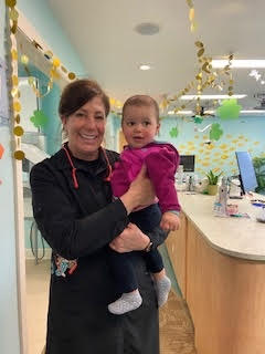 Dr. Derrow holding a baby and smiling